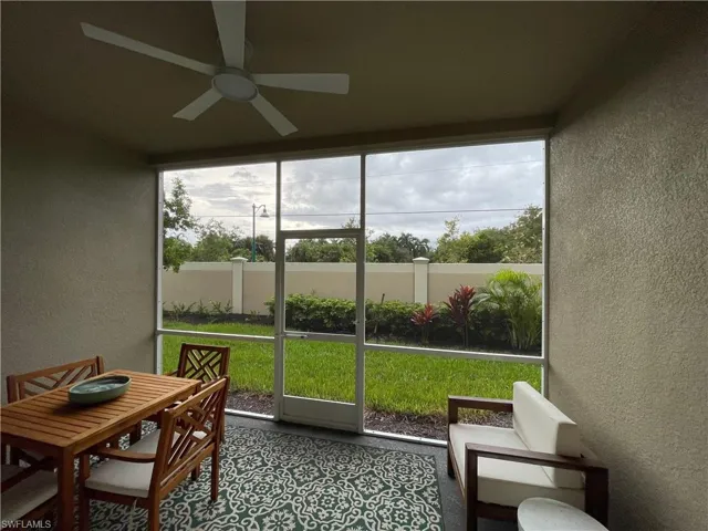 Sunroom with a textured wall and ceiling fan