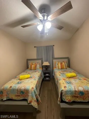 Bedroom with ceiling fan and dark hardwood / wood-style flooring