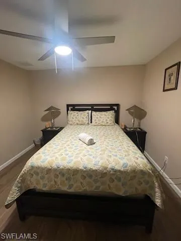 Bedroom featuring ceiling fan and dark wood-type flooring