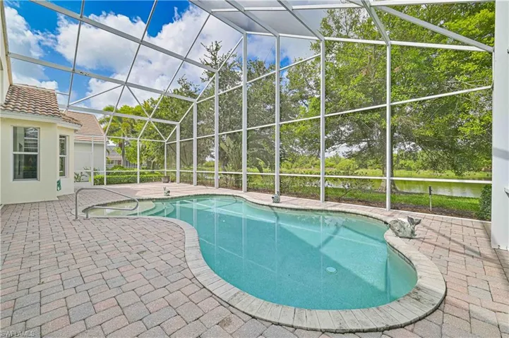 Swimming pool featuring a sunroom, a patio area, and a lanai