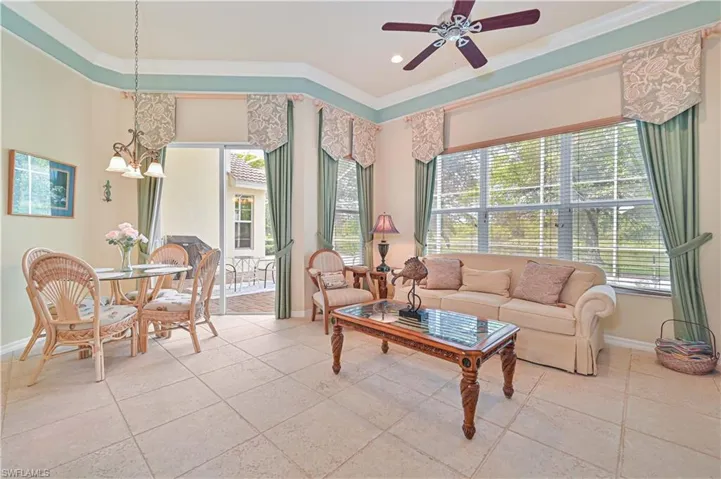 Living room with crown molding, a ceiling fan, and hanging lights