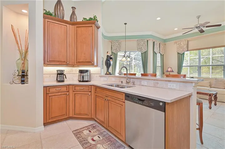 Kitchen with a peninsula, dishwasher, crown molding, decorative backsplash, and open floor plan