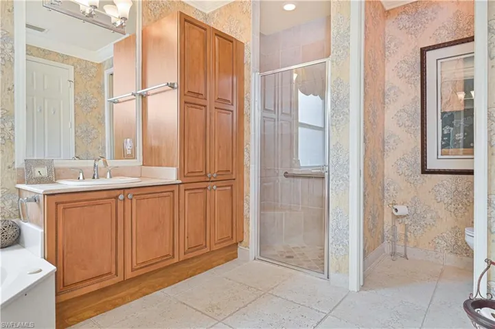 Full bathroom with wallpapered walls, vanity, a stall shower, ornamental molding, and a bath