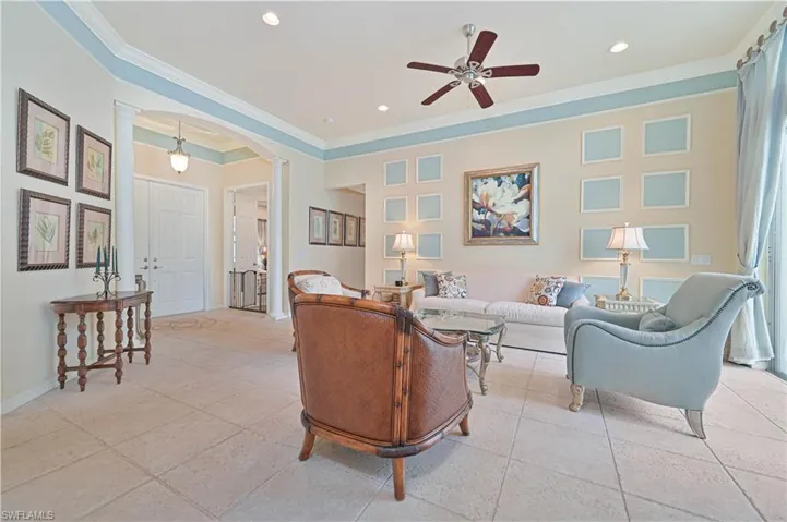 Living room with arched walkways, a ceiling fan, ornamental molding, recessed lighting, and ornate columns