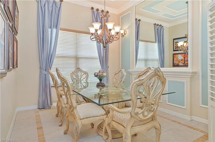 Dining area featuring inlaid floor details, hanging lights, and ornamental molding