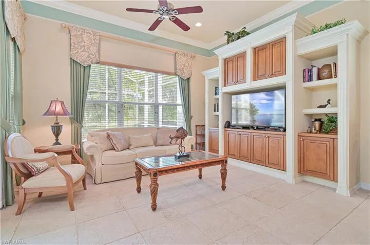 Living area featuring crown molding, ceiling fan, built in shelves, recessed lighting, and light tile patterned flooring