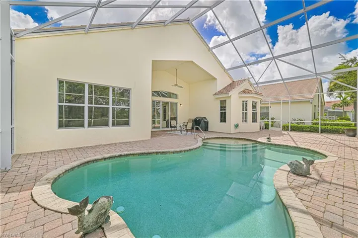 Swimming pool with a sunroom, a patio area, and glass enclosure