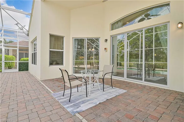 View of patio / terrace featuring a sunroom, glass enclosure, and outdoor dining space