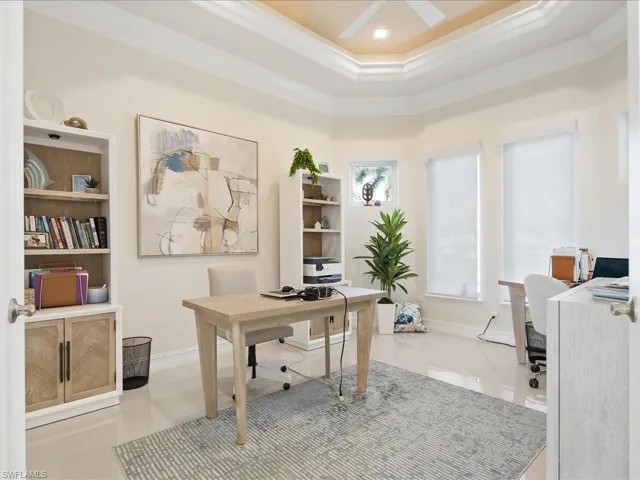 Office space featuring ornamental molding and a raised ceiling