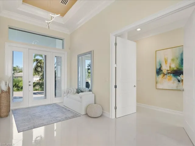Entryway featuring crown molding, french doors, and a high tray ceiling