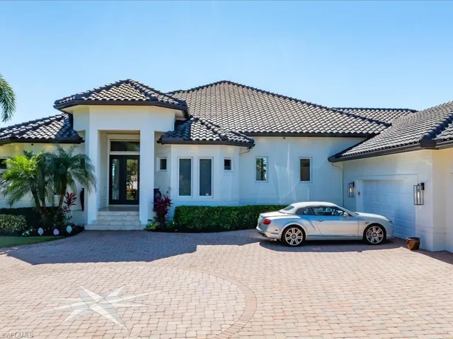 Mediterranean / spanish house with an attached garage, stucco siding, driveway, and a tile roof