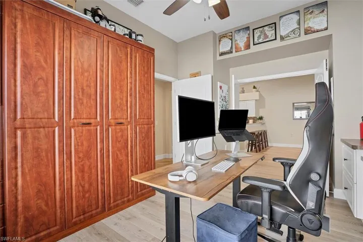 Office space featuring ceiling fan, light wood-style flooring, and Murphy Bed