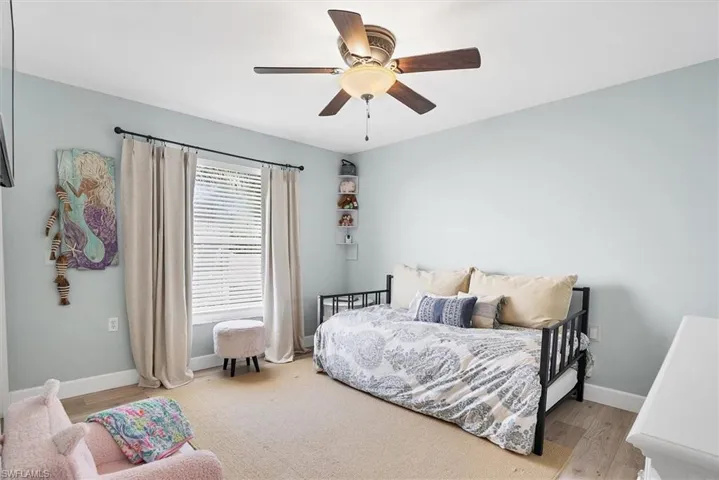 Bedroom with light wood-type flooring, baseboards, and a ceiling fan