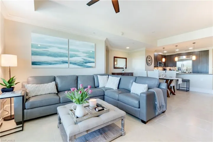 Living area featuring ornamental molding, ceiling fan, recessed lighting, a tray ceiling, and light tile patterned floors