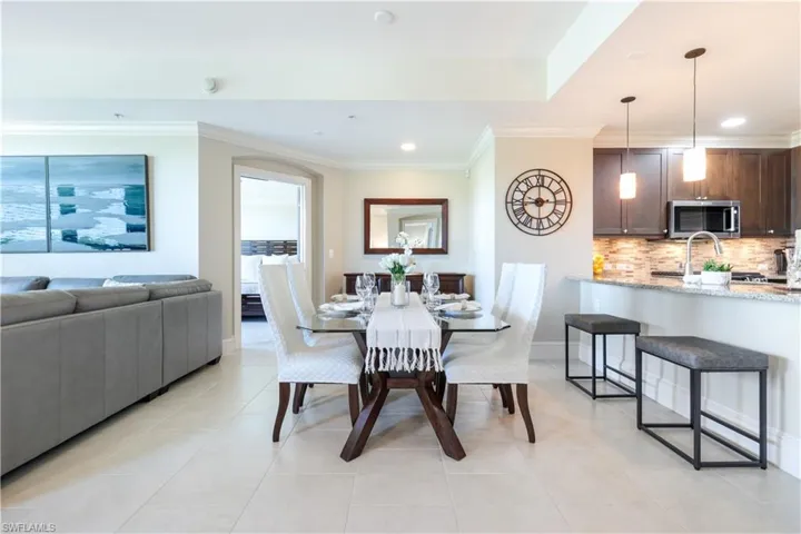 Dining room with crown molding, light tile patterned floors, and recessed lighting