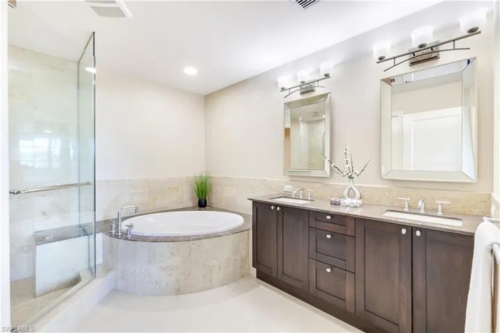 Full bath with a garden tub, double vanity, a stall shower, light tile patterned floors, and recessed lighting