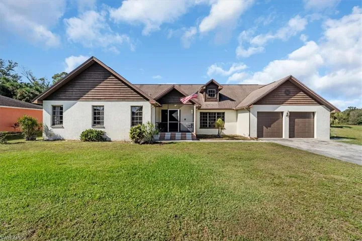 View of front of property featuring a front lawn and a garage