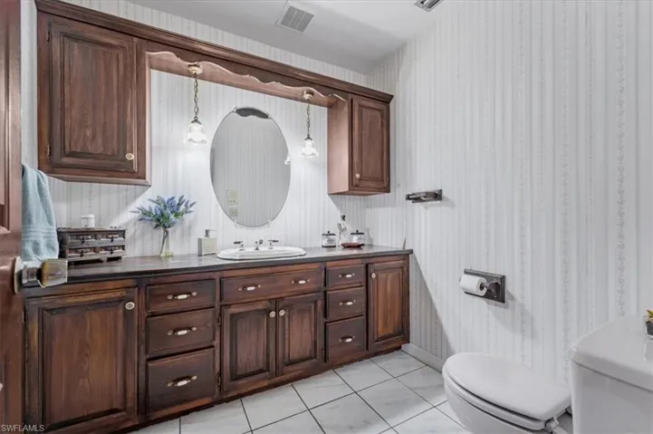 Bathroom featuring tile patterned flooring, vanity, and toilet