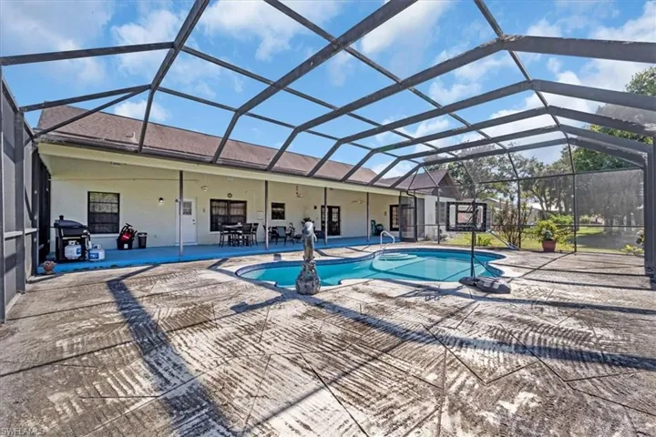 View of swimming pool with area for grilling, a patio area, and a lanai