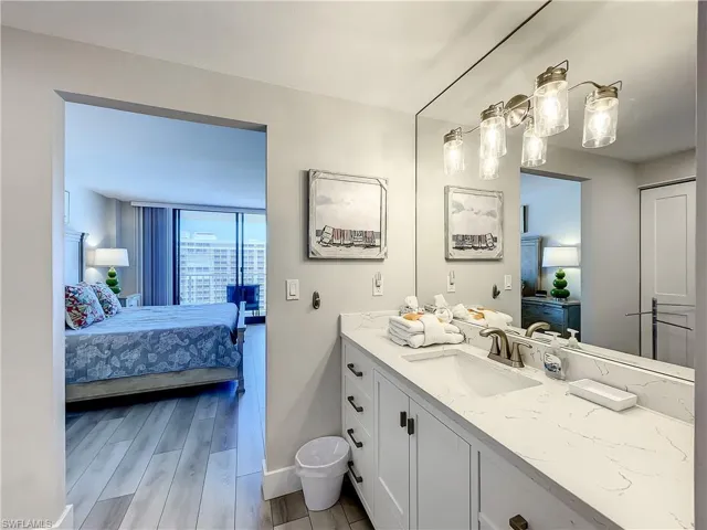 Bathroom featuring ensuite bath, vanity, and wood tiled floors