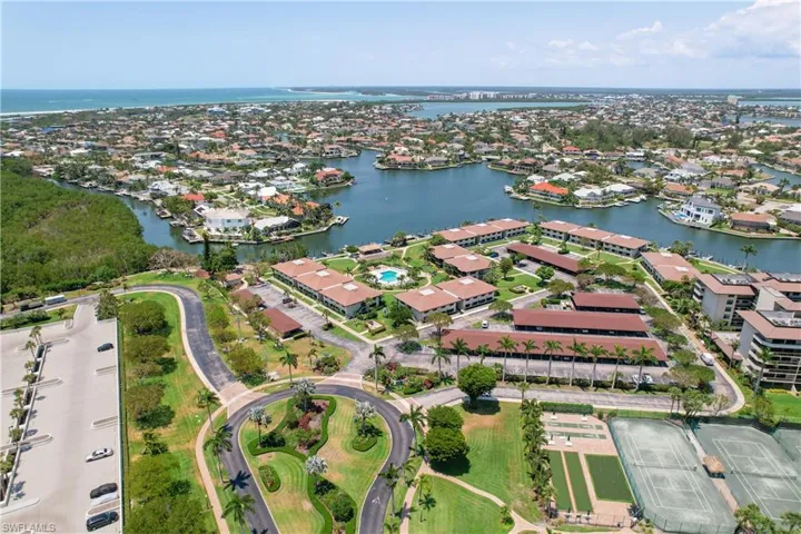 Aerial view of property and surrounding area with a nearby body of water and nearby suburban area