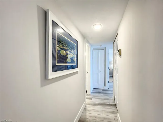 Corridor featuring baseboards and wood finish floors