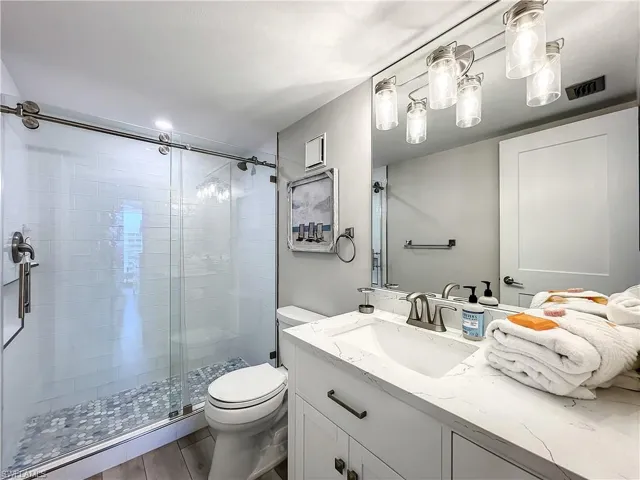 Full bathroom with vanity and a shower stall