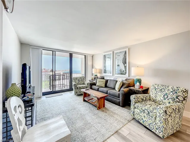 Living room featuring light wood-style floors and a wall of windows