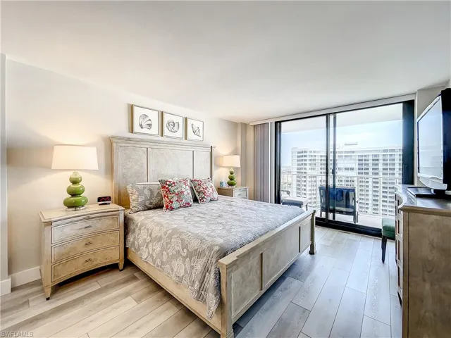 Bedroom featuring access to outside, light wood finished floors, and expansive windows