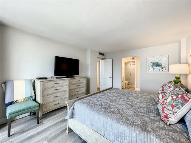 Bedroom featuring light wood-style floors and ensuite bath