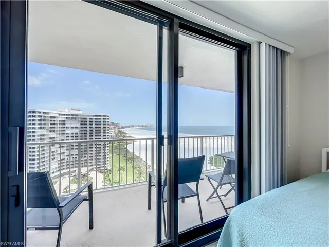 Bedroom with a water view, multiple windows, and access to outside