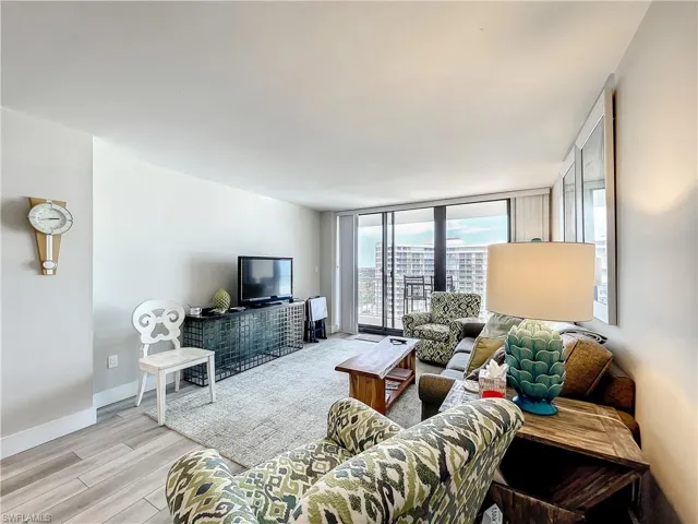 Living room with light wood finished floors and a wall of windows