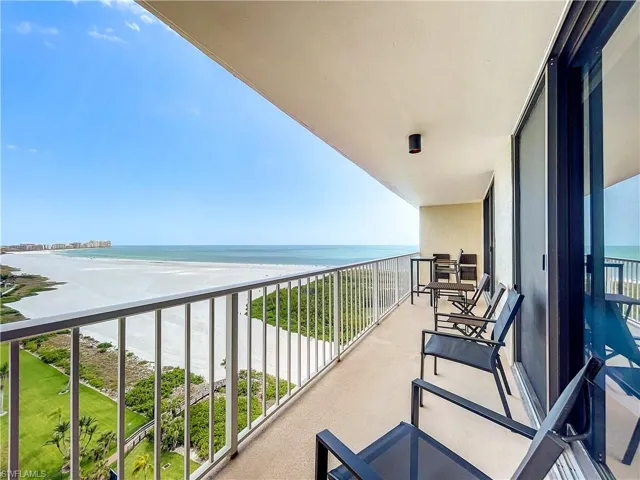 Balcony featuring view of water and beach