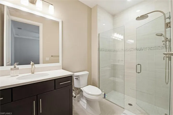 Full bath with a shower stall, vanity, and light tile patterned floors