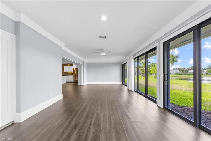Spacious interior featuring wood-finish flooring, light gray walls, and white crown molding