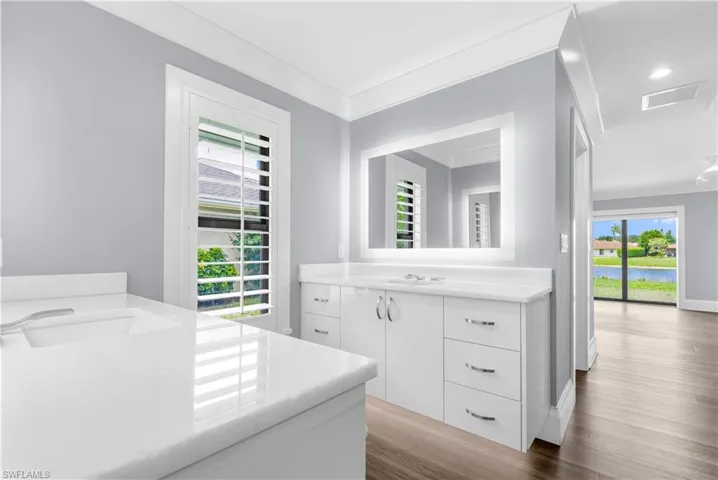 Dual vanities featuring white cabinetry and countertops