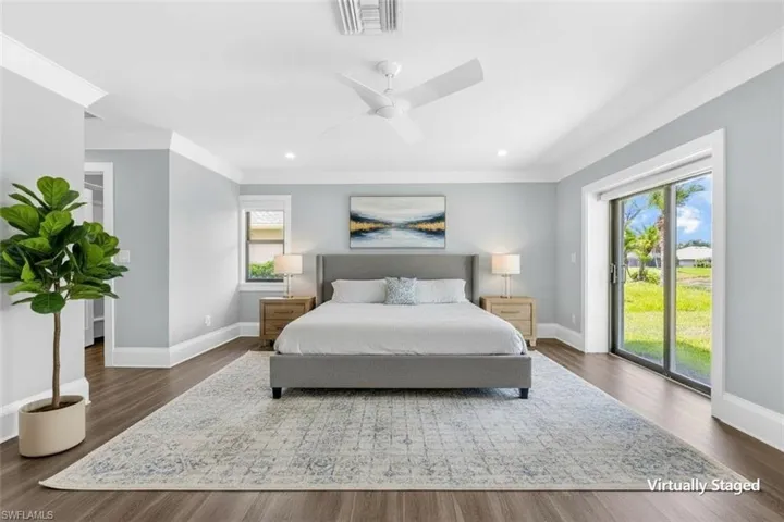 Spacious interior featuring wood-finish flooring, light blue walls, and white crown molding