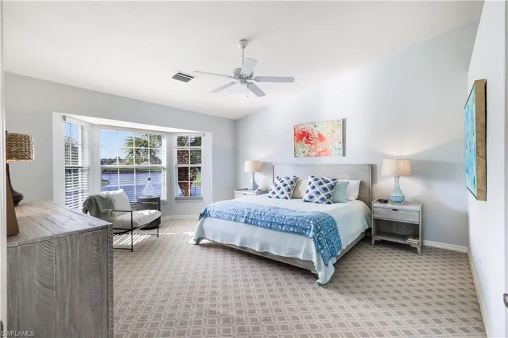 Carpeted bedroom featuring vaulted ceiling and ceiling fan