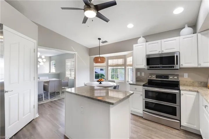 Kitchen with white cabinetry, stainless steel appliances, and light wood-type flooring