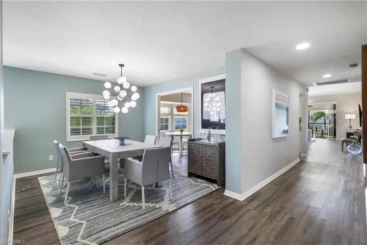 Dining space featuring a notable chandelier, a textured ceiling, and dark hardwood / wood-style floors