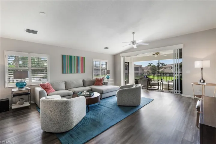 Living room with lofted ceiling, ceiling fan, and dark hardwood / wood-style flooring