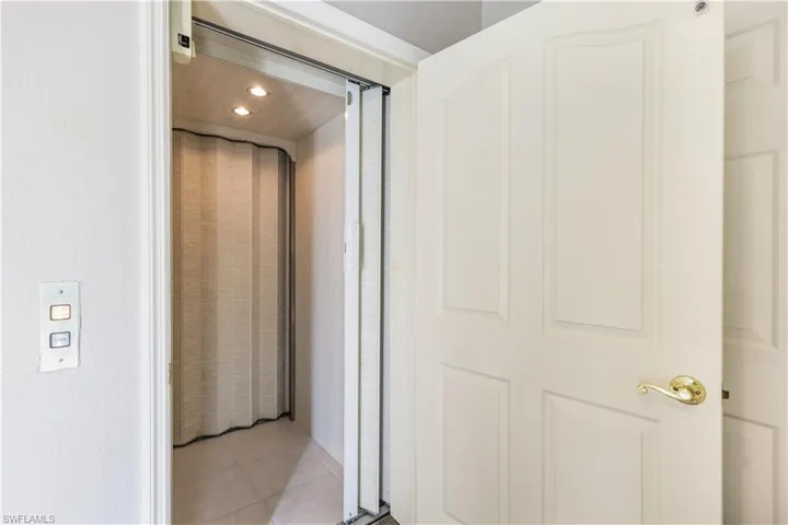 Corridor featuring light tile patterned flooring and elevator