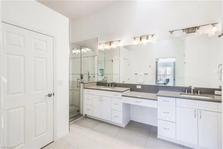 Bathroom featuring vanity, tile patterned flooring, and walk in shower