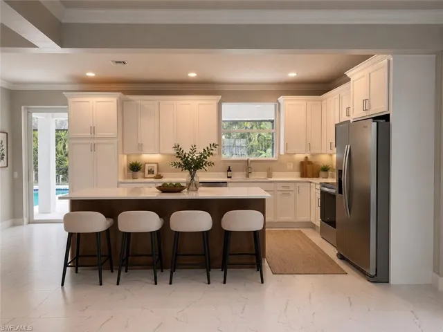 Modern kitchen featuring white shaker cabinetry, stainless steel appliances, a center island with countertop seating, and light-toned flooring