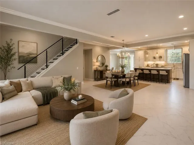 Open-concept living space featuring wood-finish flooring, a modern staircase with cable railing, recessed lighting, and crown molding