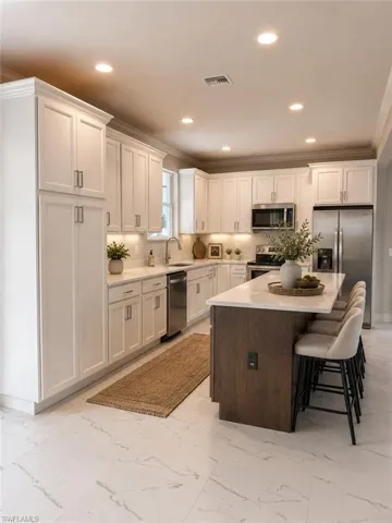 Modern kitchen featuring white shaker cabinetry, stainless steel appliances, a large center island with seating, and white marble-look flooring