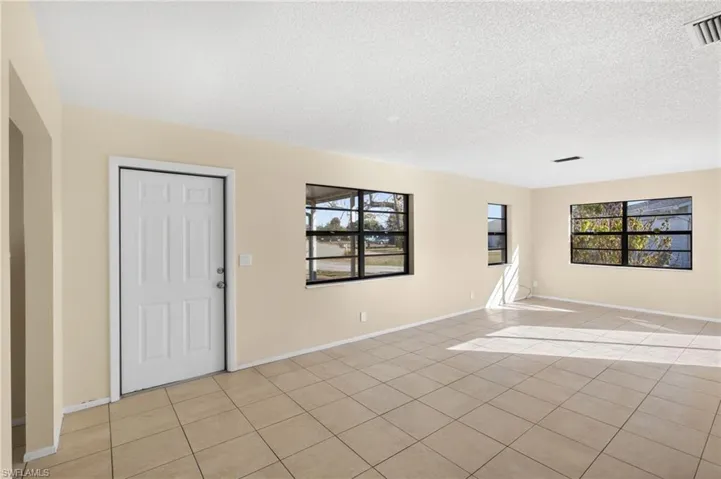 Entrance foyer with light tile patterned floors and a textured ceiling