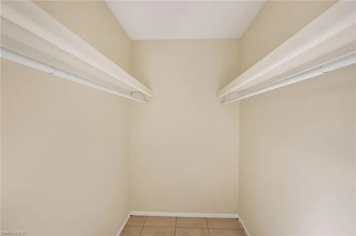 Walk in closet with light tile patterned floors