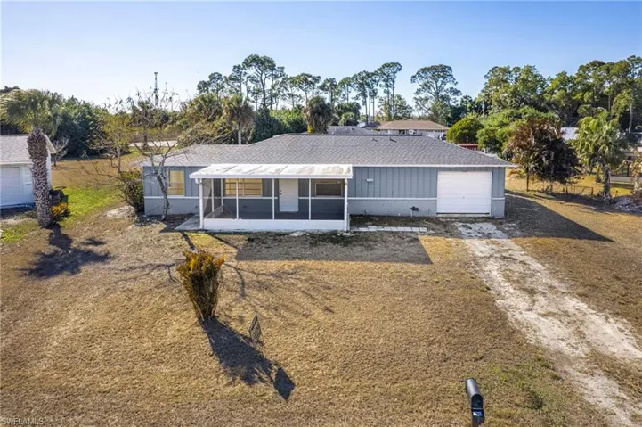 Single story home with a sunroom, driveway, and a garage