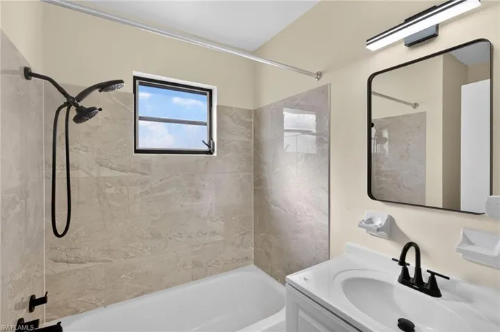 Bathroom with vanity and bathtub / shower combination